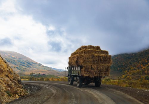 oldfashioned-truck-carrying-hay-through-scenic-mountain-pass-min